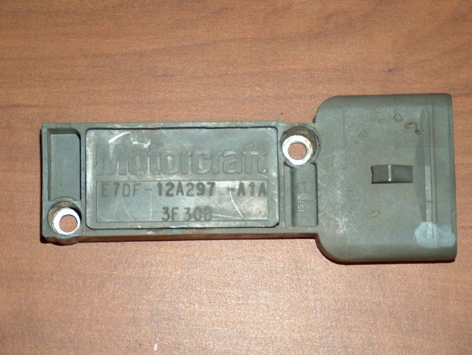 Gray Motorcraft ignition module marked E7DF-12A297-A1A on a wood surface