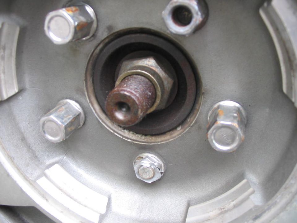 Close-up of a wheel hub with lug nuts and a central bolt