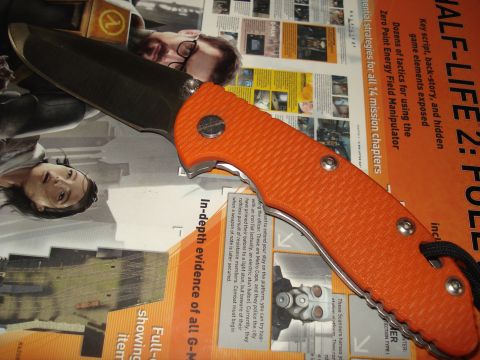 2000 Ford Crown Victoria - A close-up of an orange folding knife is placed over magazine articles and images related to the video game Half-Life 2.