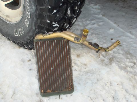 1991 Toyota Tacoma - Heater core removed from a vehicle, resting in the snow next to a tire.