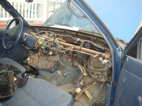 1991 Toyota Tacoma - The interior of a blue 1991 Toyota Tacoma shows a disassembled dashboard with wires and components exposed.
