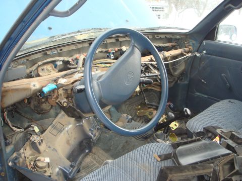 1991 Toyota Tacoma - The interior of a 1991 Toyota Tacoma shows a disassembled dashboard with the steering wheel and exposed wiring visible.
