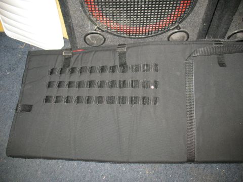 1997 Ford Crown Victoria - A black fabric organizer with MOLLE webbing and straps is shown, with a speaker visible in the background.