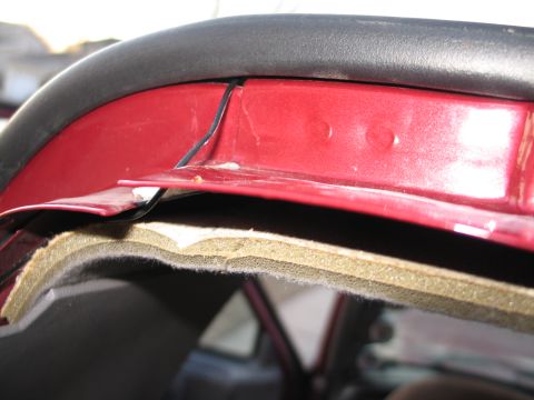 1995 Ford Bronco - Detail of the interior trim and insulation of a vehicle, showing exposed layers.