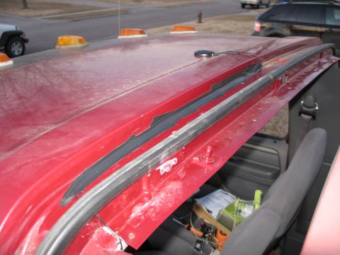 1995 Ford Bronco - A red vehicle's roof is visible, with orange lights and exposed interior components.