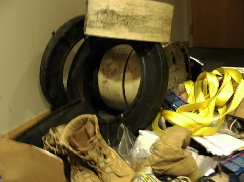 1990 Ford Bronco - A collection of large tires, tan work boots, and yellow straps are stored together.
