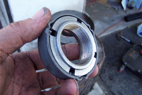 1990 Ford Bronco - Close-up of a ball joint nut being held in a hand.