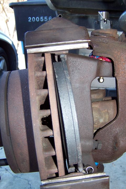 1990 Ford Bronco - Close-up view of a vehicle's brake caliper, rotor, and pads, indicating a mechanical part rather than a specific vehicle model year.