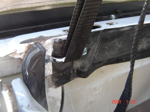 1993 Ford Bronco - Close-up view of the mounting hardware for a soft top, showing straps and bolts.