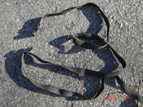 1993 Ford Bronco - Tie-down straps on asphalt.