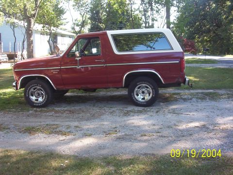 1985 Ford Bronco - This 1980s Ford Bronco SUV is shown from the side, parked outdoors on a gravel surface.