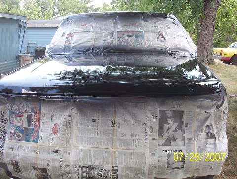 1985 Ford Bronco - Car bodywork covered in newspaper and plastic sheeting, ready for a paint job.