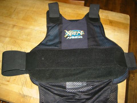 1996 Ford Bronco - A black and blue body armor vest with the "Xtreme Armor" logo is displayed on a wooden table.