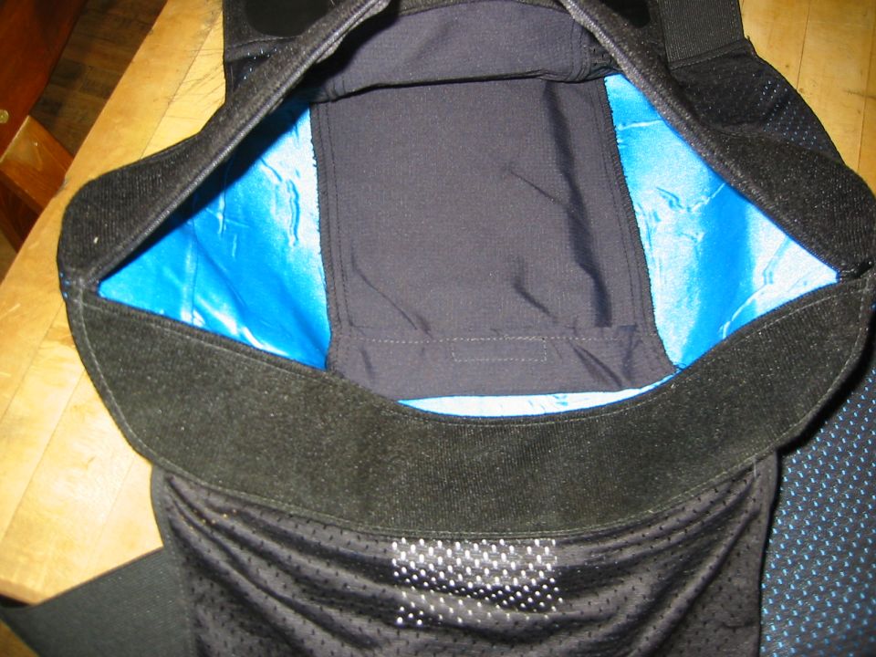 Black motorcycle knee pads with blue lining and velcro straps. Supermotors.net logo visible