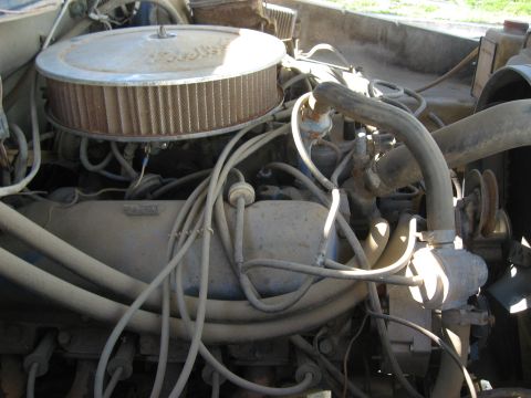 1979 Ford Bronco - Close-up view of a dusty engine bay with various components and wiring.