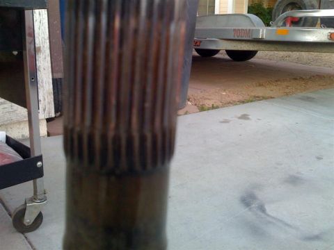 1987 Suzuki Samurai - A close-up view of a splined shaft, with a trailer and a house visible in the background.