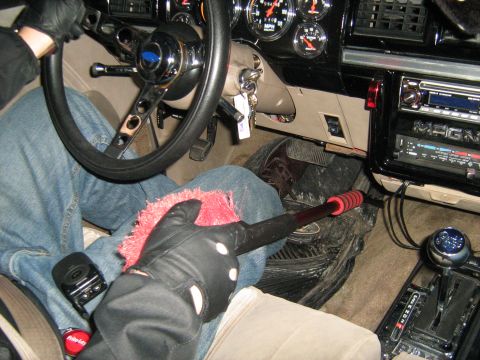 1988 Mercury Grand Marquis - Interior view of a car's dashboard and steering wheel, with a person cleaning.