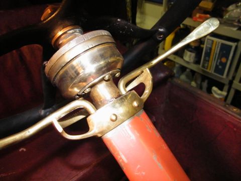 1913 Ford Model T - Detail of a steering column with brass fittings and a red painted lever.