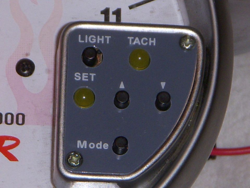 Close-up of aftermarket tachometer control panel with LIGHT, TACH, SET and Mode buttons