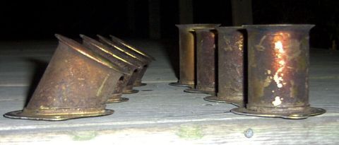 1997 Ford Taurus - A group of old, tarnished brass or copper funnels with flared rims and flat bases are arranged on a wooden deck. The funnels are of two dif…