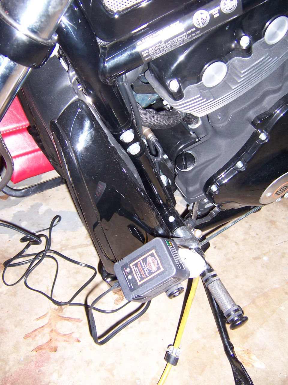 Motorcycle engine with a Harley-Davidson battery charger attached.