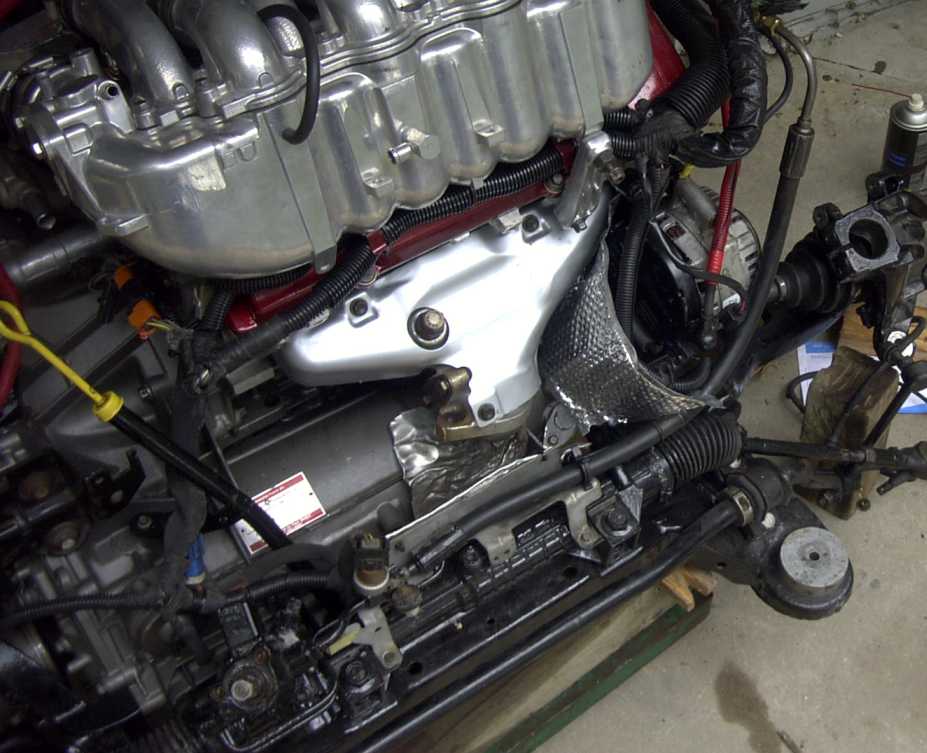 Close-up of a complex engine assembly with metal, wiring, and engine parts.