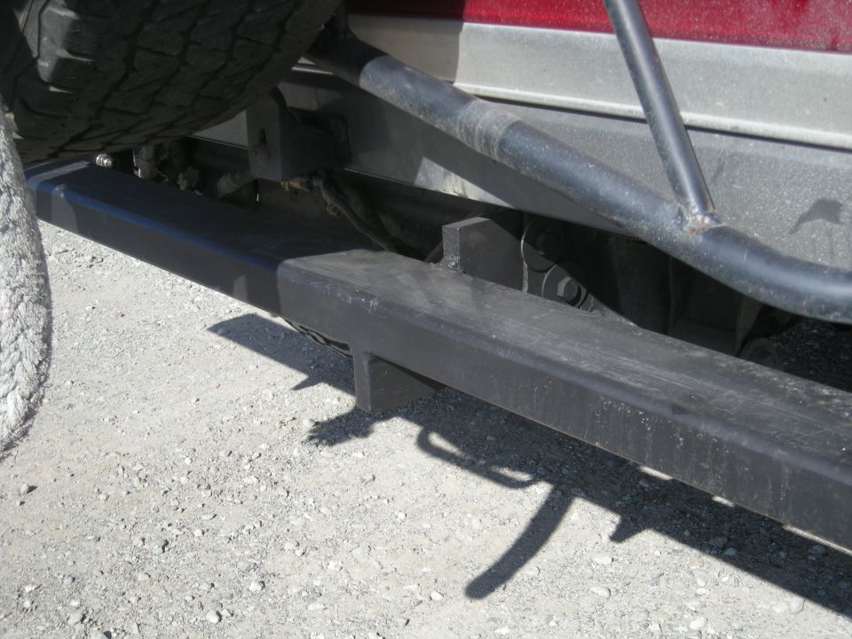 Black aftermarket rear bumper on a vehicle, with spare tire and frame visible.
