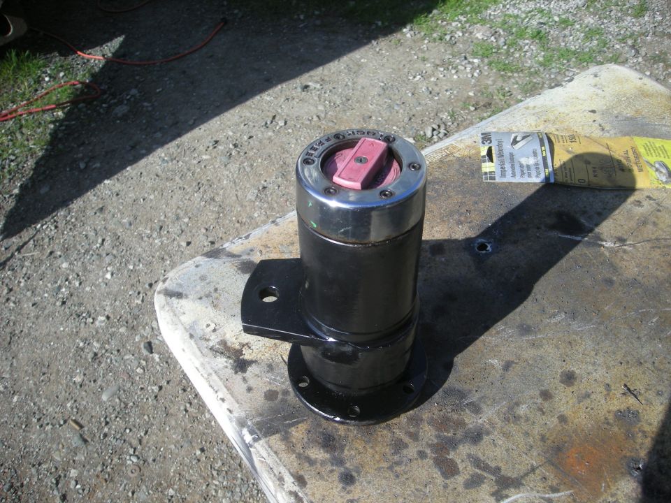 Black hub assembly with pink locking mechanism on concrete with sandpaper.