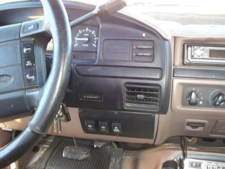 1996 Ford Bronco dashboard interior with steering wheel, instrument cluster, and aftermarket switches.