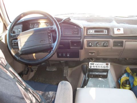1996 Ford Bronco - The interior of a 1996 Ford Bronco shows the dashboard with a CB radio mounted below the climate controls and a steering wheel with integra…
