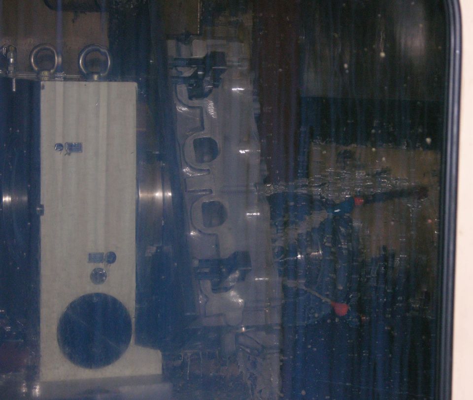 Blurred view through dirty glass of an engine casting on a machine