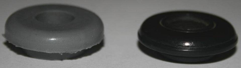 Two rubber grommets, one gray and one black, on a white surface.