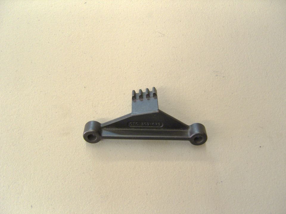 Photo of a small triangular special service tool on a tan surface