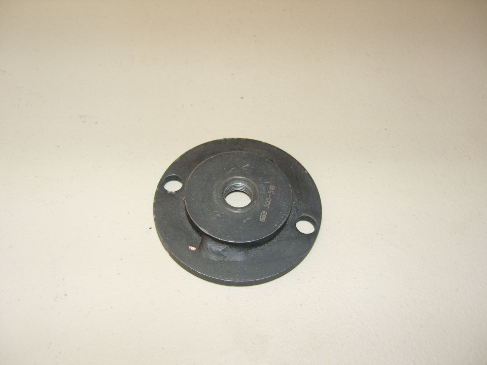 Photo of a round flanged adapter plate tool with center hole