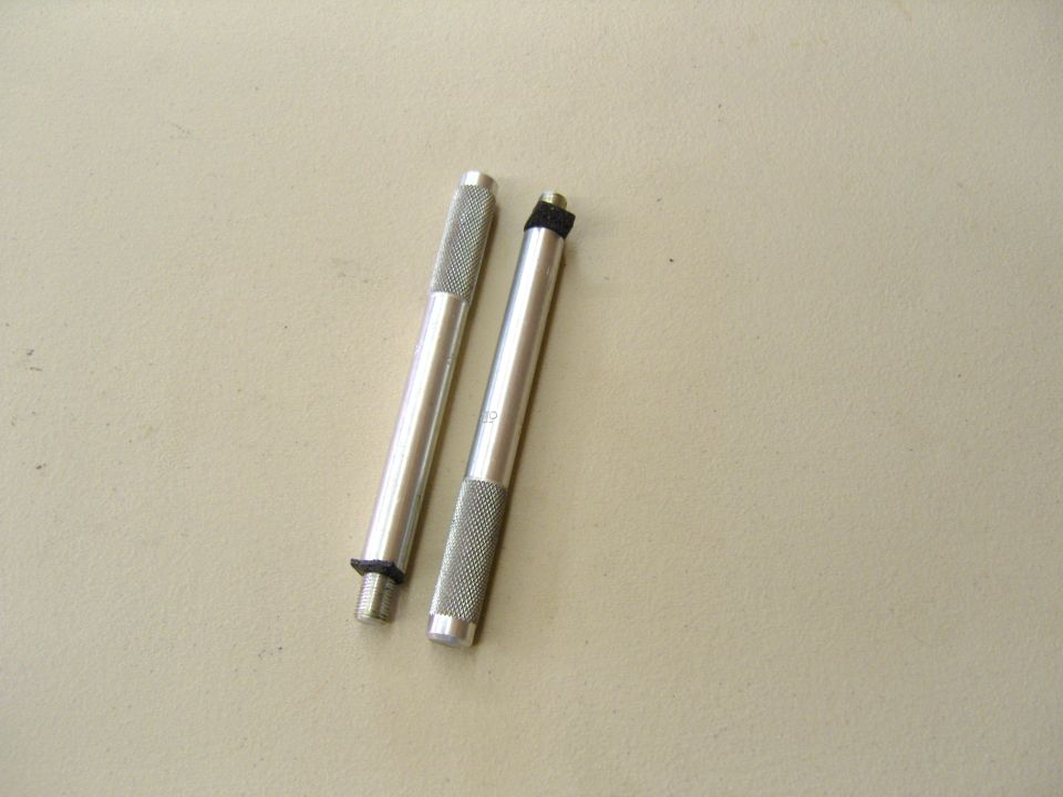 Photo of two knurled metal pin or punch tools on a tan surface
