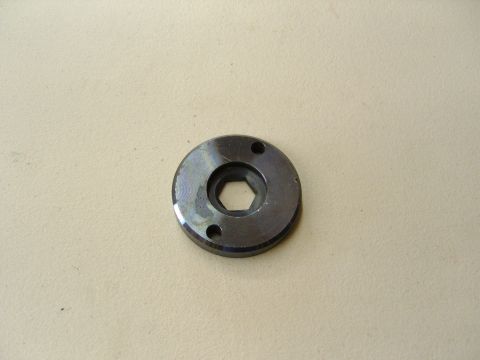 2007 Ford Mustang - Photograph of a metal flange plate with a hex center bore, not a technical document.