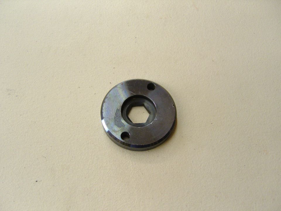 Photo of a round metal flange plate with hex center hole and two bolt holes