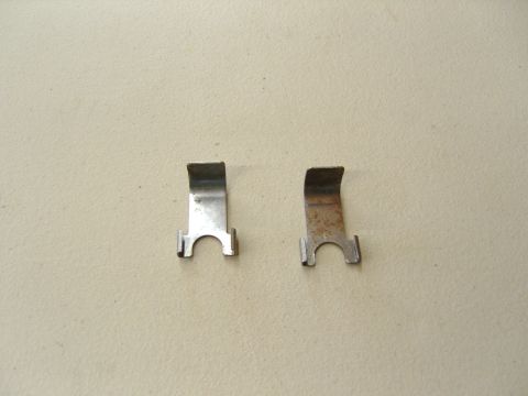 2007 Ford Mustang - Photograph of two bent sheet-metal retaining clips, not a technical document.