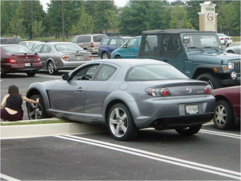 Gray Mazda RX-8 coupe parked in a lot beside a Jeep Wrangler