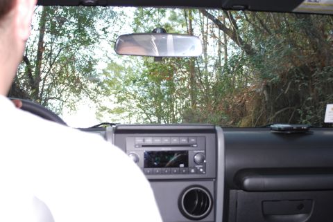 2008 Jeep Wrangler - View from inside a Jeep Wrangler, looking through the windshield at trees and a dashboard with a radio.