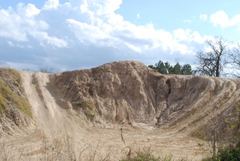 2008 Jeep Wrangler - A wide view of a large dirt mound with tire tracks, suggesting an off-road or construction site. The sky above is partly cloudy with blue s…