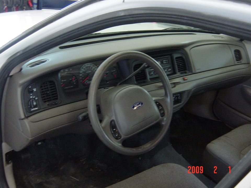 Gray dashboard and steering wheel of a 2002 Ford Crown Victoria interior