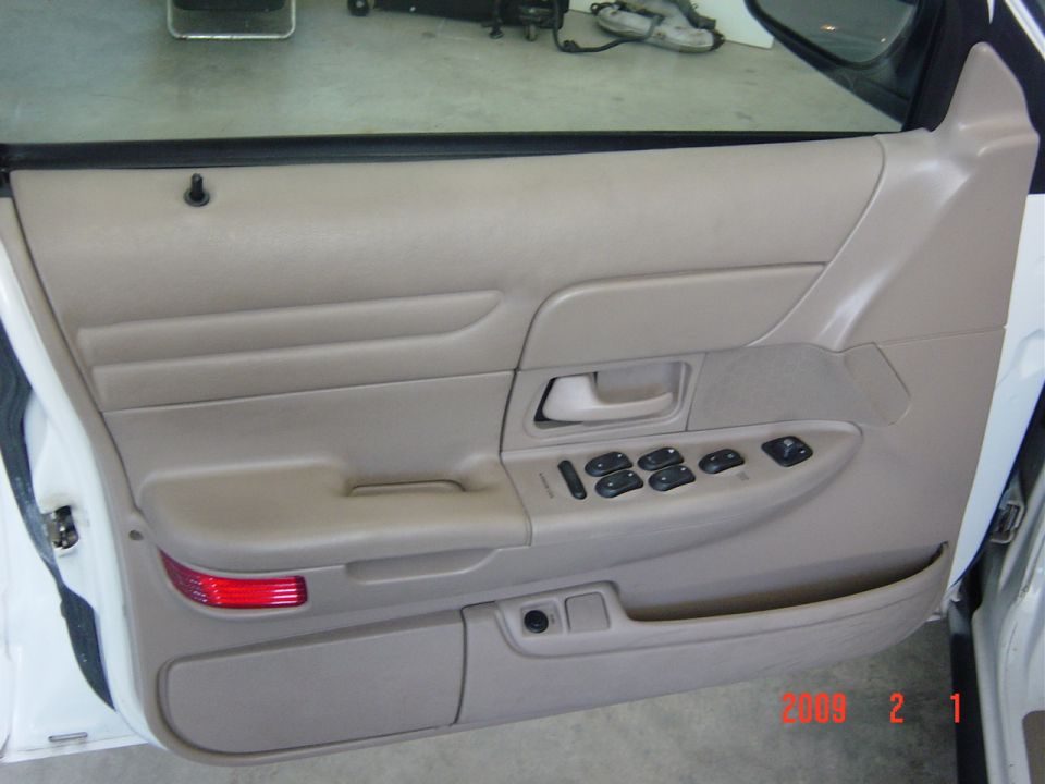 Tan interior door panel with power window controls, 2002 Ford Crown Victoria
