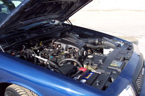 2001 Ford Crown Victoria - Engine bay of a blue 2001 Ford Crown Victoria, hood fully open.