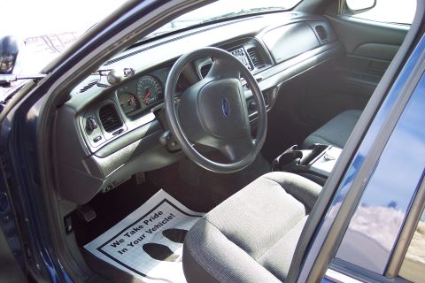 2001 Ford Crown Victoria - The interior of a 2001 Ford Crown Victoria, a police-style dashboard and floor mat with text.