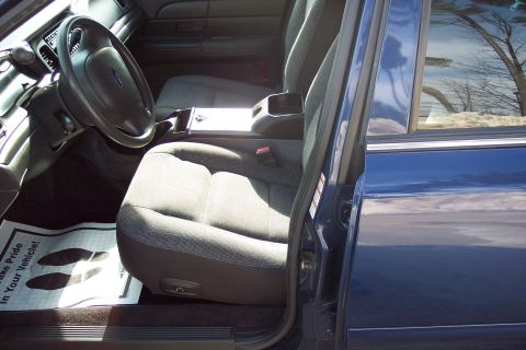 2001 Ford Crown Victoria - The interior of a blue 2001 Ford Crown Victoria is shown, with a floor mat displaying footprints and text.