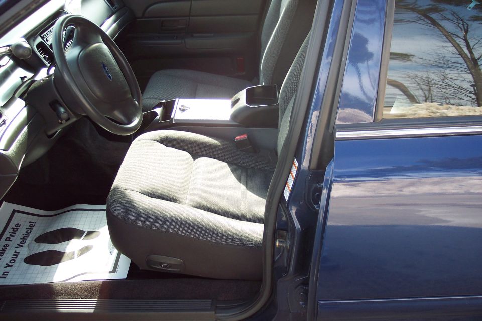 Interior of a blue 2001 Ford Crown Victoria, showing front seats, steering wheel, and door panel