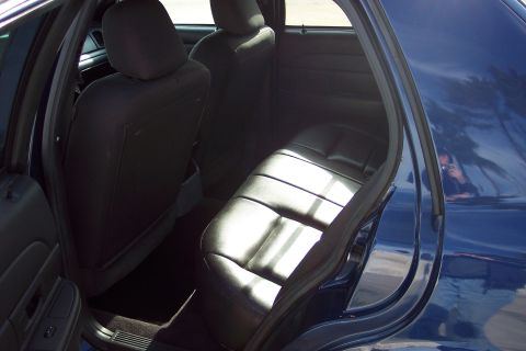 2001 Ford Crown Victoria - The interior of a dark blue sedan is visible, focusing on the rear seating area.