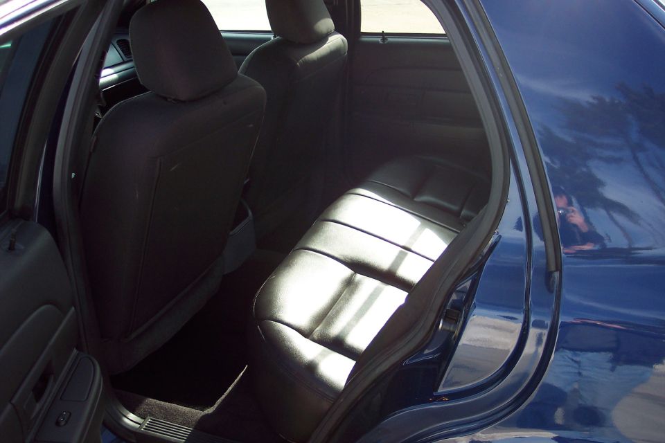 Interior of a dark blue sedan showing the rear bench seat and door panel