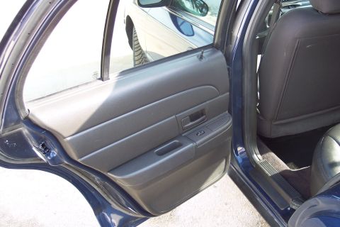 2001 Ford Crown Victoria - Rear interior view of a 2001 Ford Crown Victoria, showing the door panel and seat.